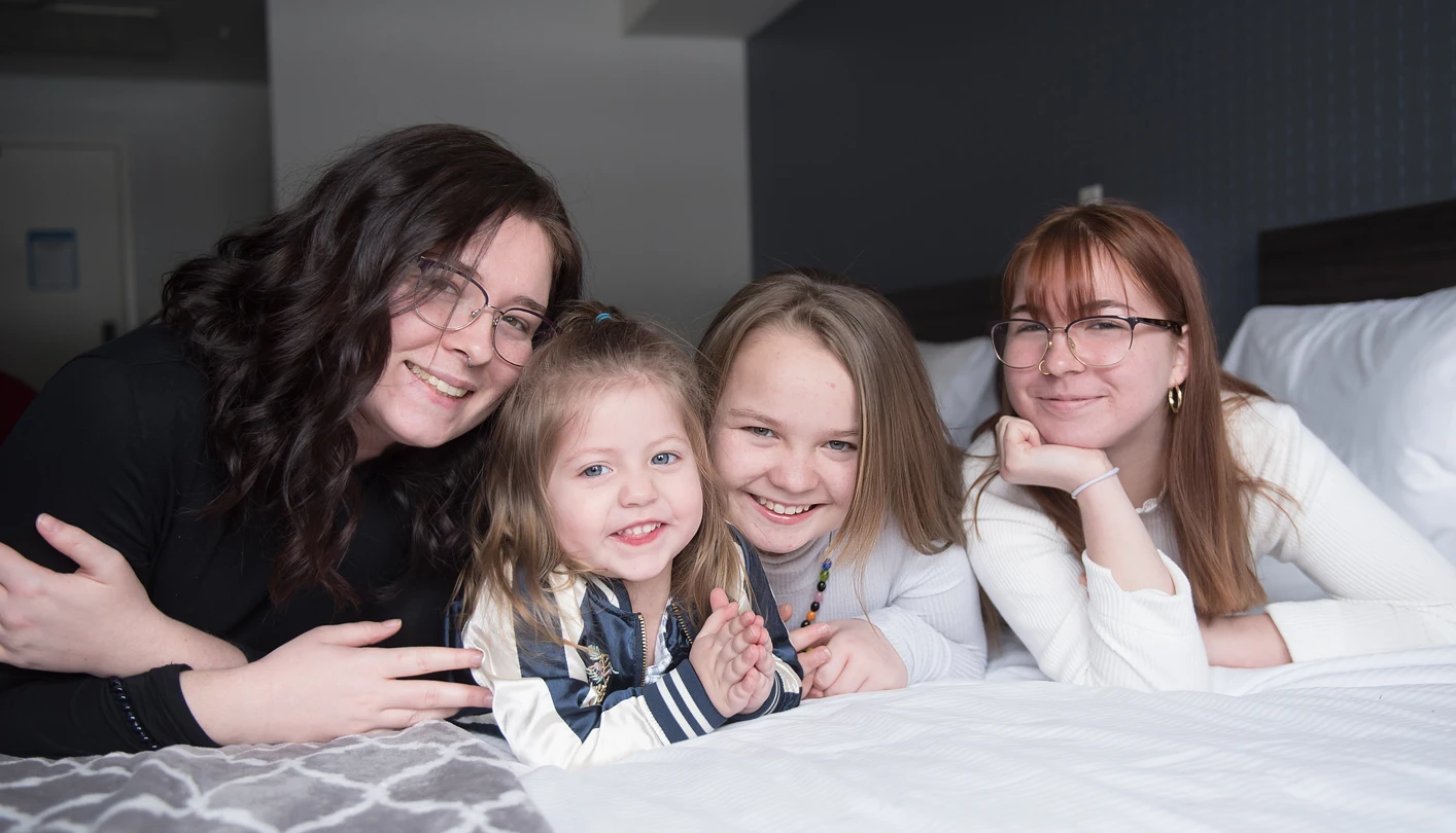 the mallais family laying on a bed